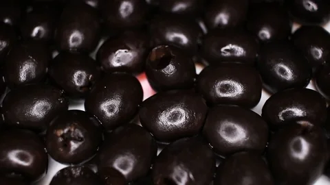 Black olives closeup texture video on rolling rotating looping plate Stock Footage 104329085
