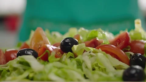 Black Olives Falling into Fresh Green Salad in Slow Motion 4K 動画素材 344052491