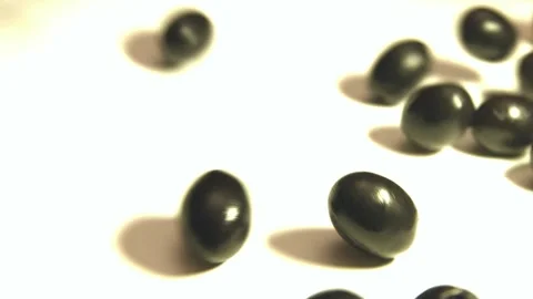 Black olives on a white background. 1 Shot.  Slow motion. Close-up. Stockbeeldmateriaal 90651006