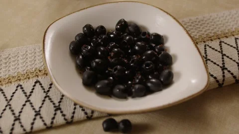 Black Olives in White Dish on Patterned Tablecloth, Close-Up Turkish Food Scene Stock Footage 345277147