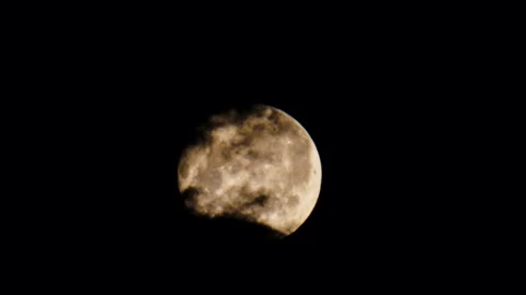 Black ominous clouds float against the backdrop of a bright full clear moon Stockbeeldmateriaal 244057866