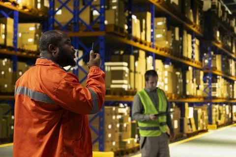 Black operator reporting parcel status via two-way portable transceiver Stock Photos