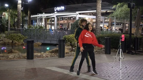 Black Or Hispanic Man And Woman Doing Tictok Video At Night In Front Of Icon Stockbeeldmateriaal 128064724