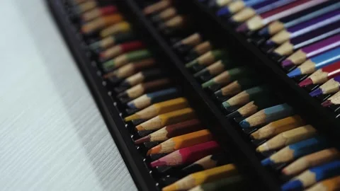 Black pack/box of colored pencils lying on white table Stock Footage 133958301