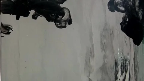 Black paint falling down in clear water on grey background Stock Footage 291114074