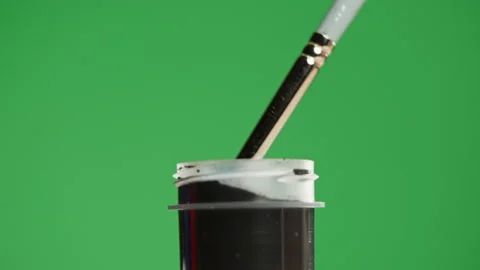 Black paint isolated on green background. Dark gouache falling from paintbrush Stock Footage 178607391