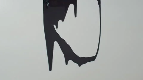 Black paint slowly runs down the white surface Video stock 253225412