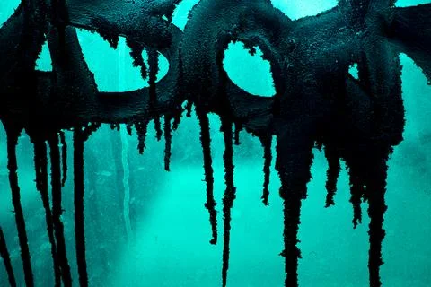 Black paint on wall. Paint is leaking. Details of vandalism. Graffiti inscr.. Stock Photos