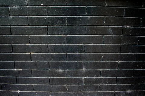 Black Painted Brick Wall with Dramatic Texture and Minimalist Lighting Stock Photos
