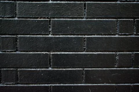 Black Painted Brick Wall with Dramatic Texture and Minimalist Lighting Foto stock
