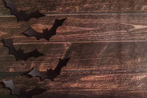 Black paper bat silhouettes on brown wooden background, Halloween concept, top Stock Photos