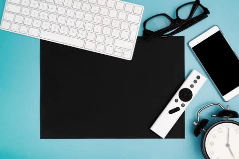 Black paper copyspace with computer keyboard, glasses, smartphone and clock.  Stock Photos