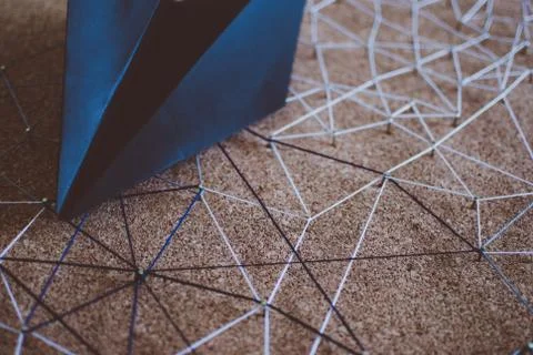Black paper plane over the threads linking the nails. Entities connected. Foto stock