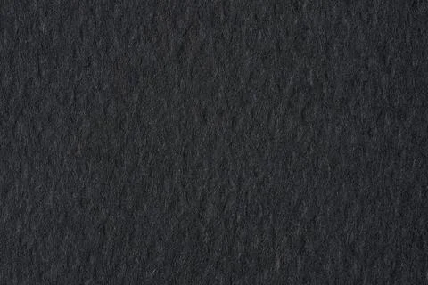 Black paper texture background with rough grain and dark dramatic tone Stockfoto's