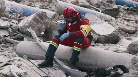 Black paramedic using smartphone after disaster Stockbeeldmateriaal 166144554