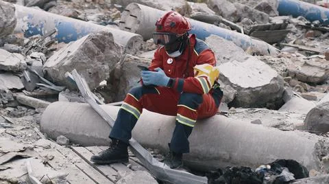 Black paramedic using smartphone after disaster 스톡 사진