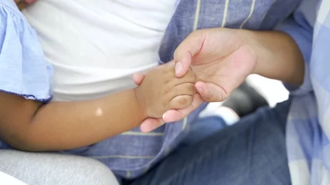 Black parent hands holding newborn baby fingers, Close up father's hand holding Видео 172298226
