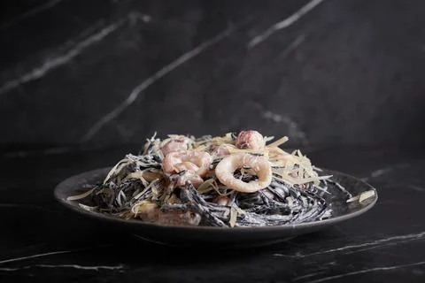 Black pasta with shrimp and seafood, spaghetti, noodles, plate on a dark Stock Photos