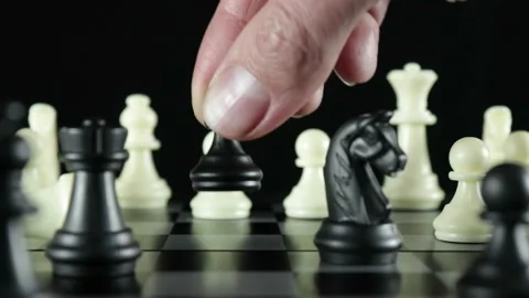 Black pawn cuts down white queen on chessboard Stock Footage 145385573