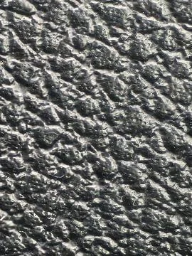 Black pebbled textured surface close-up Stock Photos