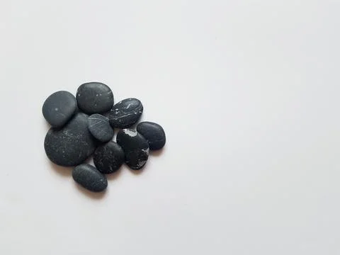 Black pebbles on white isolated background with mock up Stock Photos