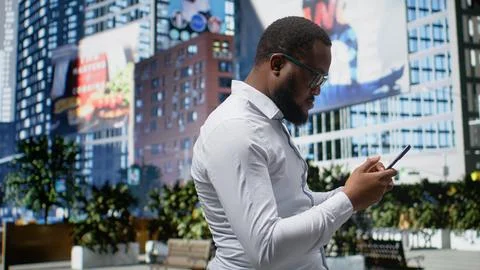 Black pedestrian navigating on smartphone apps and walking with confidence Stock Photos