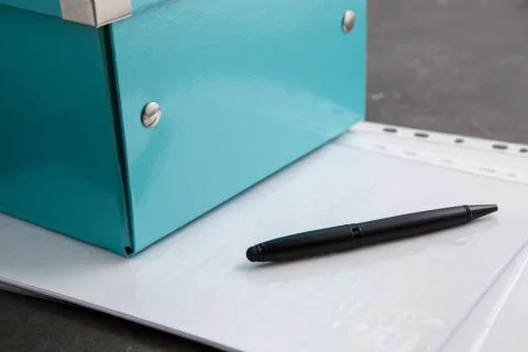 Black pen on documents on a gray table Stock Photos