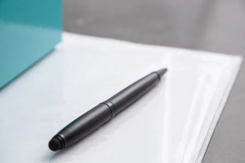 Black pen on documents on a gray table Stock Photos