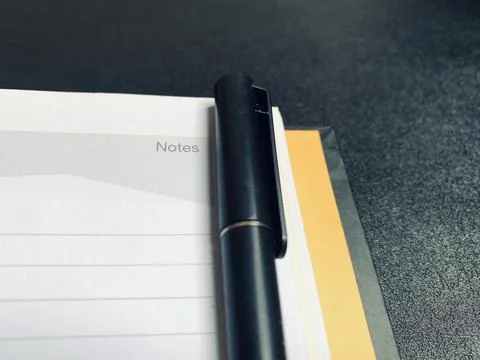 Black Pen Lying on Open Lined Notepad Page Notes Header Close Up View Stock Photos