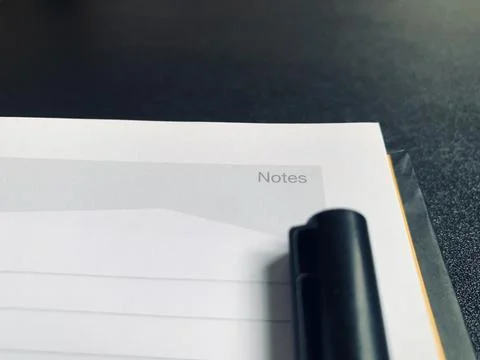 Black Pen Lying on Open Lined Notepad Page Notes Header Close Up View Stock Photos