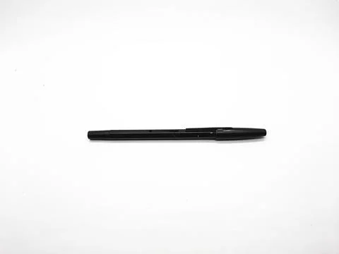 Black pen lying on a white surface in a minimalist studio environment Stock Photos