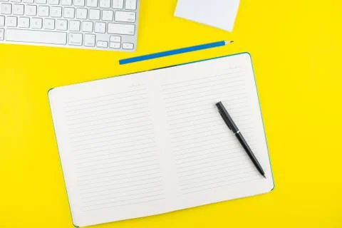 Black pen, notepad planner, pencil and keyboard on yellow background. Flat la Stock Photos