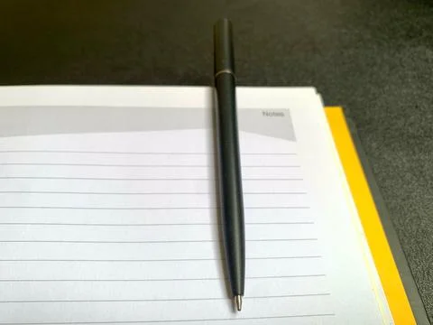 Black Pen Placed Vertically on Open Lined Spiral Notebook Top View Stock Photos