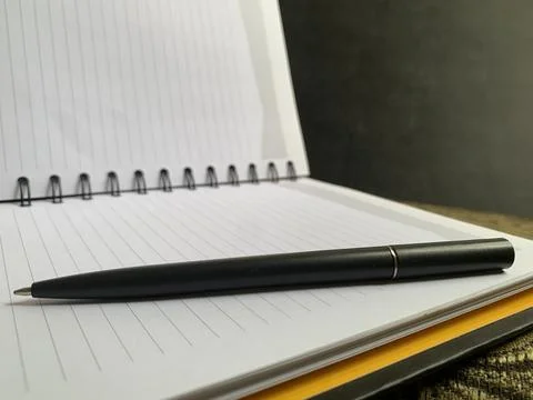 Black Pen Resting Horizontally on Open Lined Spiral Notebook Close Up Macro View Stock Photos
