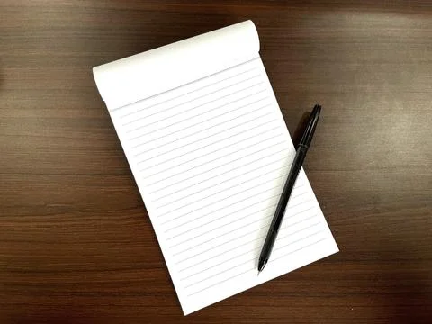 Black pen on a white lined notebook Stock Photos