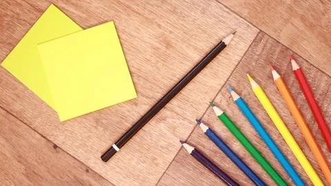 Black pencil between multicolored pencils and stickers Stock Footage 99954911