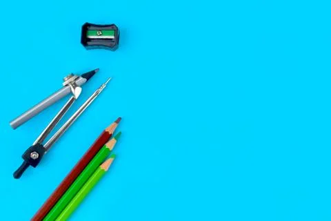 A black pencil sharpener along side a pencil attached to a pencil compass and Stock Photos