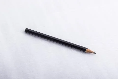 A black pencil, on a white surface. Stock Photos