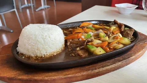 Black pepper beef stew with vegetables and rice served on hot plate Stock Footage 288263182