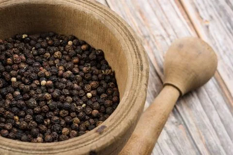 Black pepper corn into mortar and pestle Stock Photos