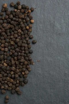 Black pepper on dark stone background Stock Photos