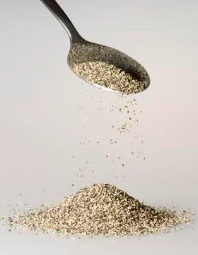 Black Pepper Falling from Tablespoon Stock Photos