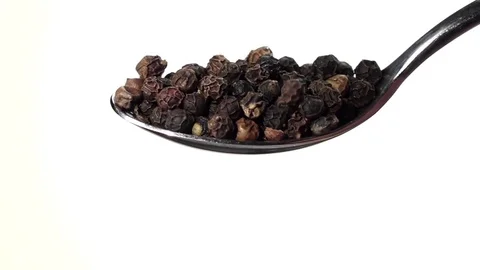 Black pepper peas falling from the iron spoon. White background. Slow motion Stock Footage 75523831