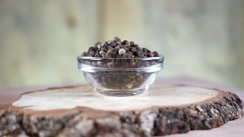 Black pepper in peas in a glass socket on a wooden stand rotates Stock-Footage 137900317