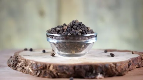 Black pepper in peas in a glass socket on a wooden stand rotates Stock-Footage 137916687