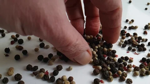 Black pepper peas spice flies on a white background hand Stock Footage 87399502