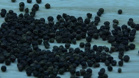 Black pepper pellets fall on the wooden table Stock Footage 79962447