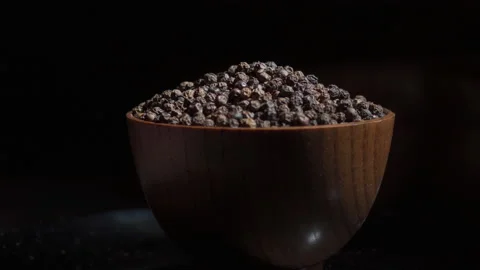 Black peppercorns in a spinning cup on a dark background Stock Footage 159764242