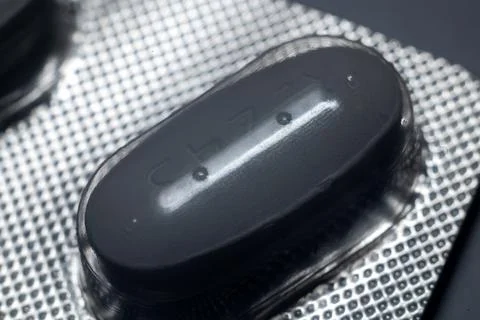 Black pill in the package Macro Foto stock