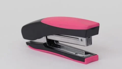 Black pink office stapler rotates isolated on white Stock Footage 276375897